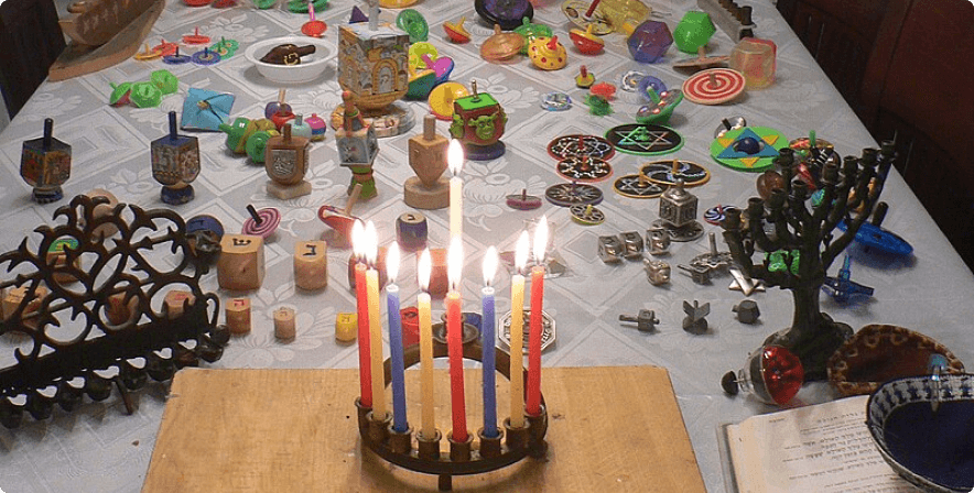 Hannukah table with menorahs and dreidel spinning tops